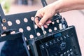 Close up view of a hand of a sound technician connecting a panel in stage