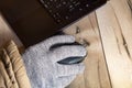 Close up view of a hand in a warm glove using a computer mouse Royalty Free Stock Photo