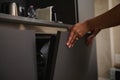 Close-up view, Hand of a woman using a modern dishwasher in the kitchen, closing the door of automatic dishwasher Royalty Free Stock Photo