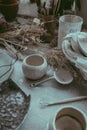 A close-up view of a handmade clay bowl on the painted white table on the surface and dried flowers on background Royalty Free Stock Photo