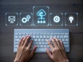 Hands typing on keyboard with futuristic digital icons representing cloud technology and data. Royalty Free Stock Photo