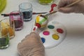 Close up view of hands child to paint Easter eggs with special utensils. Holiday concept. Royalty Free Stock Photo