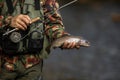 Close-up view of the hands of a fly fisherman holding a lovely trout
