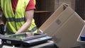 Close-up view of the hands of a manufacturing worker putting packed products in cardboard boxes, before export or Royalty Free Stock Photo