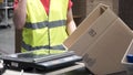 Close-up view of the hands of a manufacturing worker putting packed products in cardboard boxes, before export or Royalty Free Stock Photo