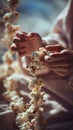 Person\'s hands stringing fluffy popcorn kernels for a festive garland in soft, natural light. Royalty Free Stock Photo