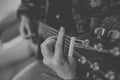 Close up view of hands playing guitar in black and white. Young woman playing guitar. Royalty Free Stock Photo