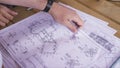 Close up view on hands pointing at technical drawings lying on the table. Man hands indicating some details in papers Royalty Free Stock Photo