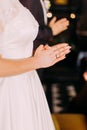 The close-up view of the hands of the praying bride.