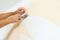 Close-up view on hands with a scraper in the process of removing wallpaper. Royalty Free Stock Photo
