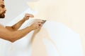 Close-up view on hands with a scraper in the process of removing wallpaper. Royalty Free Stock Photo