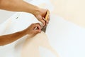 Close-up view on hands with a scraper in the process of removing wallpaper. Royalty Free Stock Photo