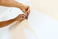 Close-up view on hands with a scraper in the process of removing wallpaper. Royalty Free Stock Photo