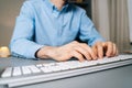 Close-up of unrecognizable man using computer and typing online message on wireless keyboard Royalty Free Stock Photo