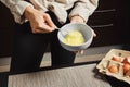 Close up view of hands of woman whipping eggs in a bowl