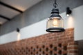 Close up view of hanging vintage ceiling yellow lamp and brick wall interior Royalty Free Stock Photo
