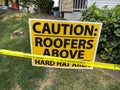 Close up view of a hard hat area sign with caution tape outside of a roof construction zone Royalty Free Stock Photo