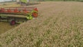 A close-up view of a harvester cutting wheat in a field. Royalty Free Stock Photo