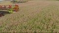 A close-up view of a harvester cutting wheat in a field. Royalty Free Stock Photo