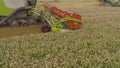 A close-up view of a harvester cutting wheat in a field. Royalty Free Stock Photo