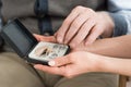 View of hearing aid box in woman and senior man hands Royalty Free Stock Photo