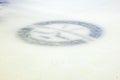 Close-up view of hockey emblem with sticks and puck beneath surface of ice rink. Royalty Free Stock Photo