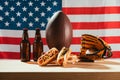 close-up view of hot dogs, beer bottles, rugby ball and baseball glove with ball on wooden table with us flag Royalty Free Stock Photo