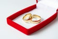 Close-up view of husband and wife wedding rings in red gift box isolated on a white background