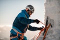 close-up view of ice axe and man climber with equipment and ropes on the slope Royalty Free Stock Photo