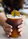 Close-up view, Ice mixed fruit juice in a woman hand, Orange flavored fruit juice drink.