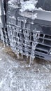 Close-up view of icicles in front of a car, winter in full swing Royalty Free Stock Photo