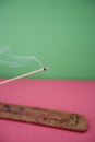 Close-up view of incense stick burning over colored background Royalty Free Stock Photo