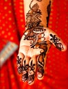 Indian henna or herbal way of traditional temporary tattooing on a womans hand