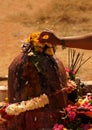 View of Indian Hindu woman offer prayers to stone carved god Shiva in shape of Lingam on maha shivaratri Royalty Free Stock Photo