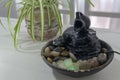 Zen water fountain next to a plant Royalty Free Stock Photo