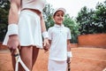 Close up view of Instructor or coach teaching child how to play tennis on a court Royalty Free Stock Photo