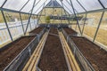 Close up view of interior of greenhouse prepared for planting vegetables.