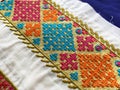 Close up view of Intricate multi colored geometric thread embroidered border