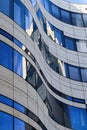 Close up view on isolated curved facade of modern architecture building with blue glass window reflections