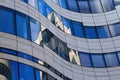 Close up view on isolated curved facade of modern architecture building with blue glass window reflections