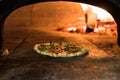 close up view of italian pizza baking in brick oven Royalty Free Stock Photo