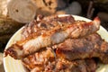 Close up view of juicy pork steak on fork cooked on an open flame grill on big white plate..