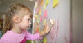 Close-up view of kid washes off the board in class with sponge Royalty Free Stock Photo