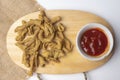 Close up view of kripik usus ayam and red chili sauces on wooden cutting board Royalty Free Stock Photo