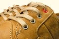 Close-up view of lacing on tan color, leather sneakers isolated on white background.