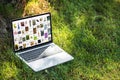 close up view of laptop with pinterest website on grass