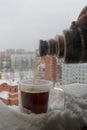 Close-up view of a large double-walled glass mug standing on a snow-covered parapet with black hot coffee. Royalty Free Stock Photo