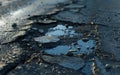A close-up view of a large pothole in an asphalt road, highlighting the need for repair and maintenance. Royalty Free Stock Photo