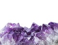 Close up view of large violet amethyst crystal cluster border isolated with white background.