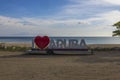 Close up view of large white letters I love Aruba at sunset. Big red heart replaces word love.